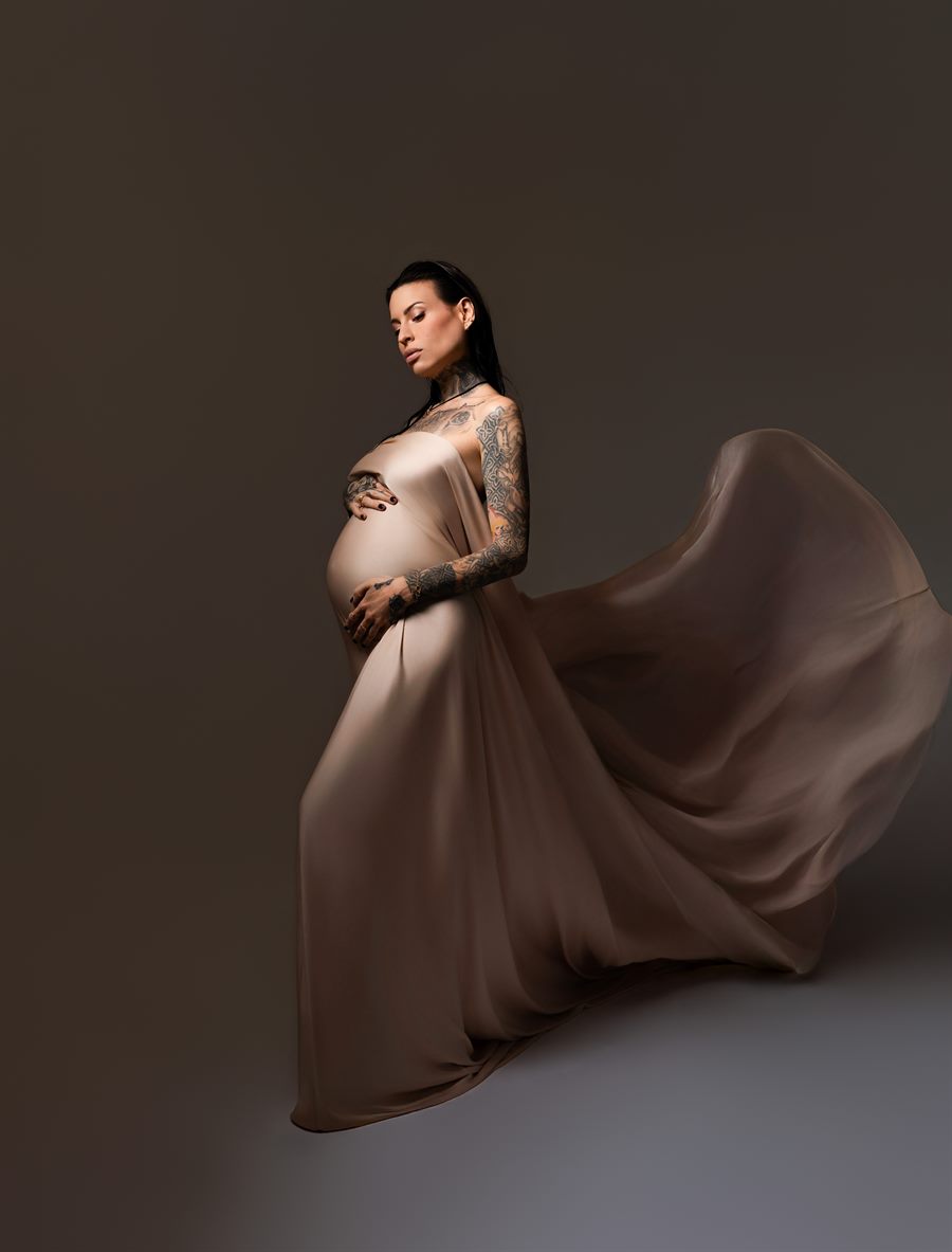 Future maman en robe longue sur fond sombre