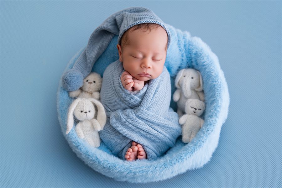 Bébé endormi contre une peluche blanche